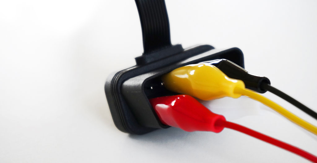 Gros plan macro sur un boîtier télématique moderne avec connecteur Can-bus visible, détail de la LED de statut et des ports de connexion dans un environnement véhicule contemporain